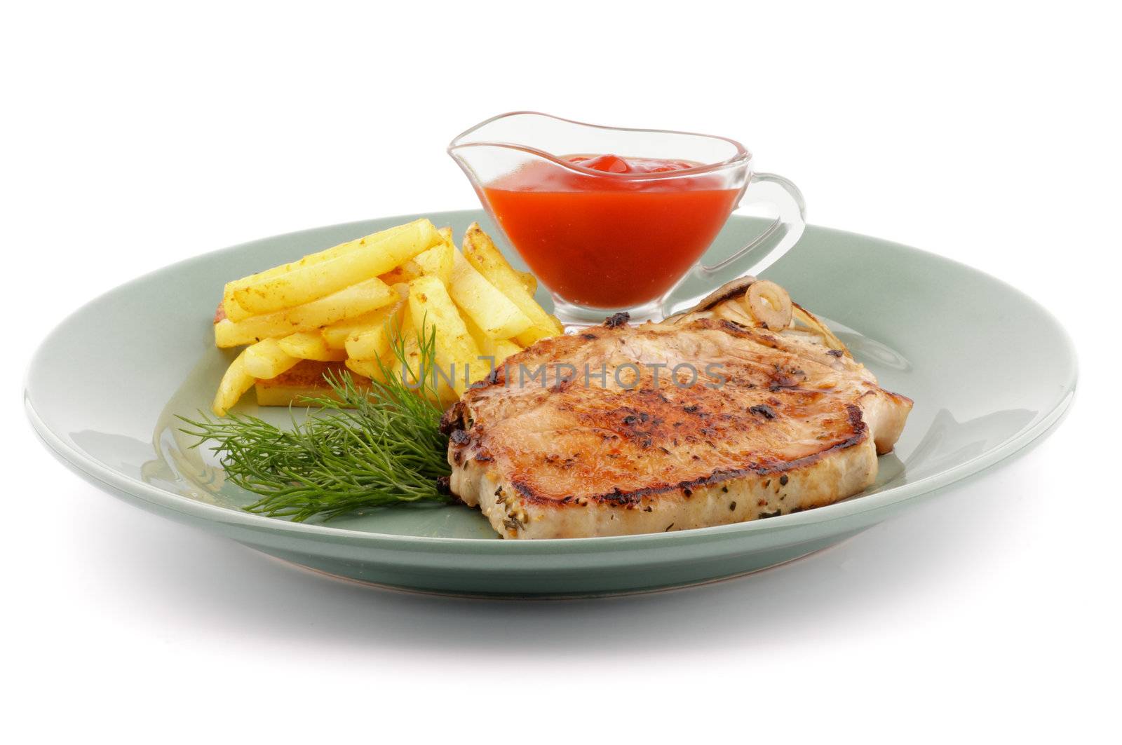 Delicious Pork Steak, French Fries, Grilled Onions, Ketchup and Dill close up on green plate