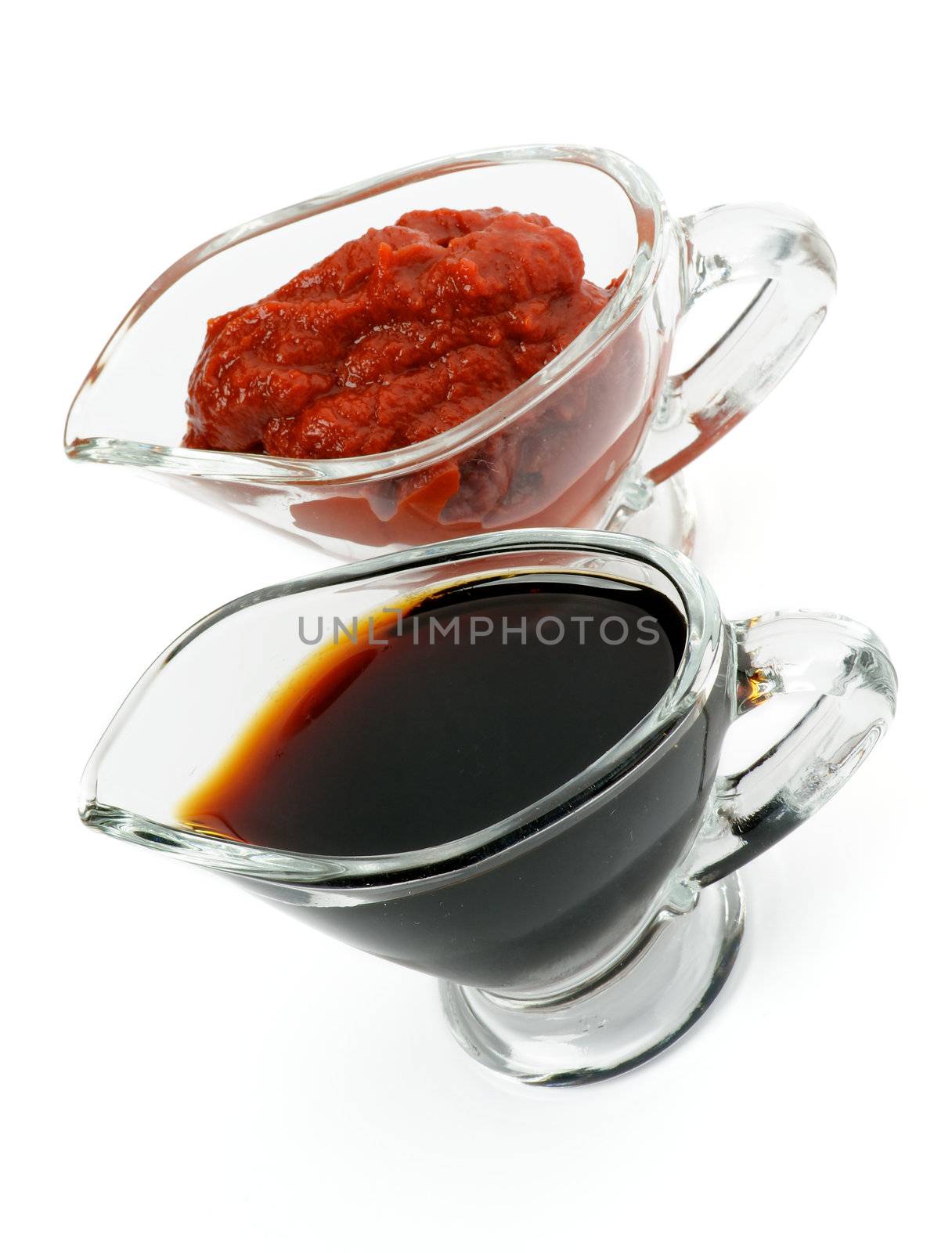 Arrangement of Soy Sauce and Ketchup in Glass Gravy Boat isolated on white background