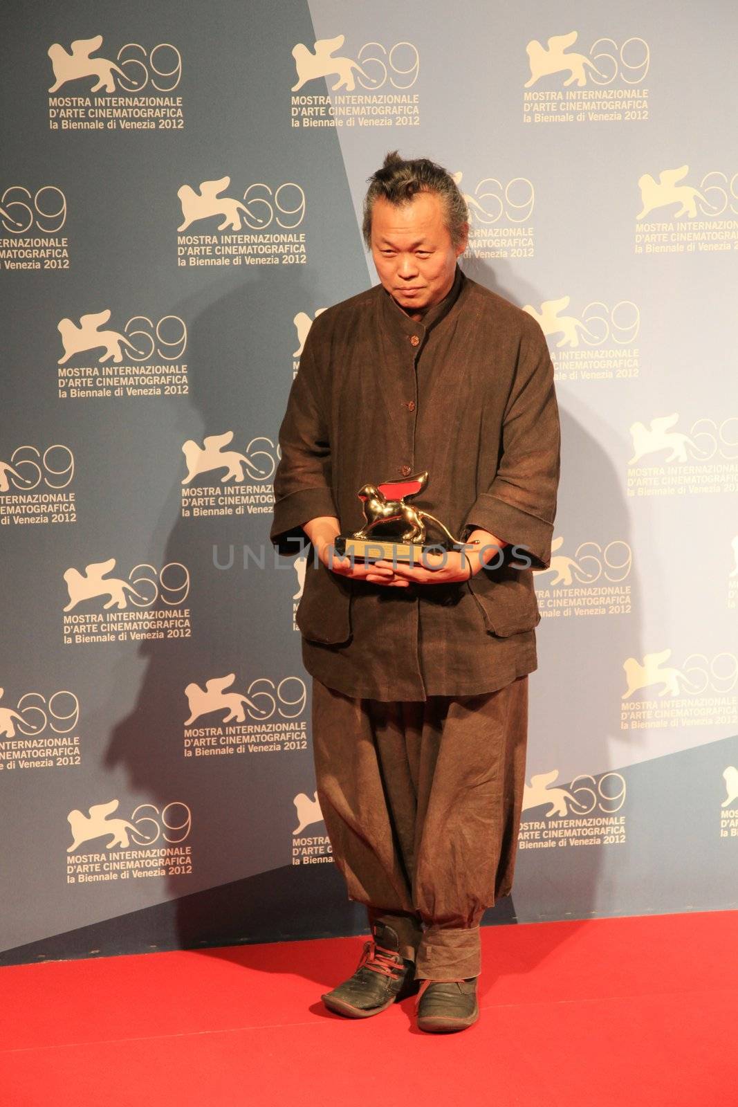 Kim Ki-duk poses for photographers at 69th Venice Film Festival