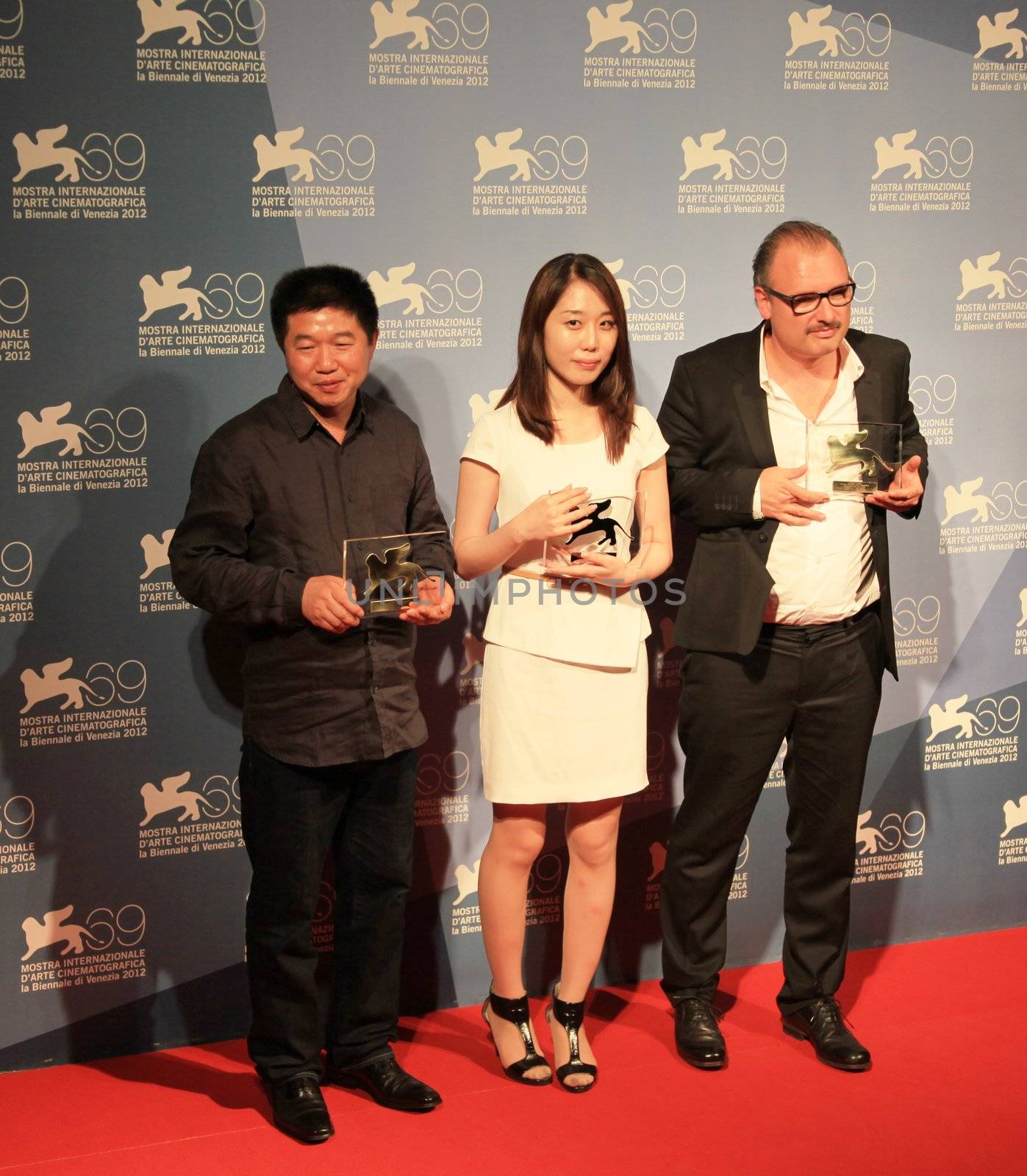 Wang Bing, Yoo Min-young and Frederic Fonteyne pose for photographers at Venice Film Festival