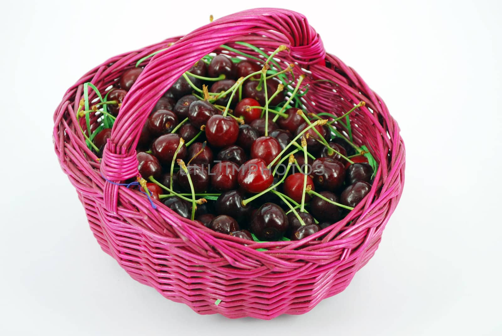 Basket with cherries isolated on white