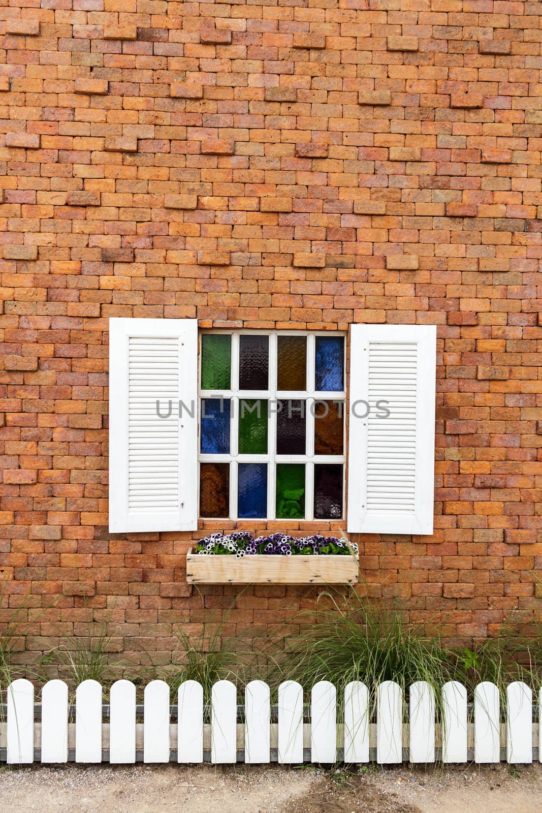 Colorful glass window on brick wall.