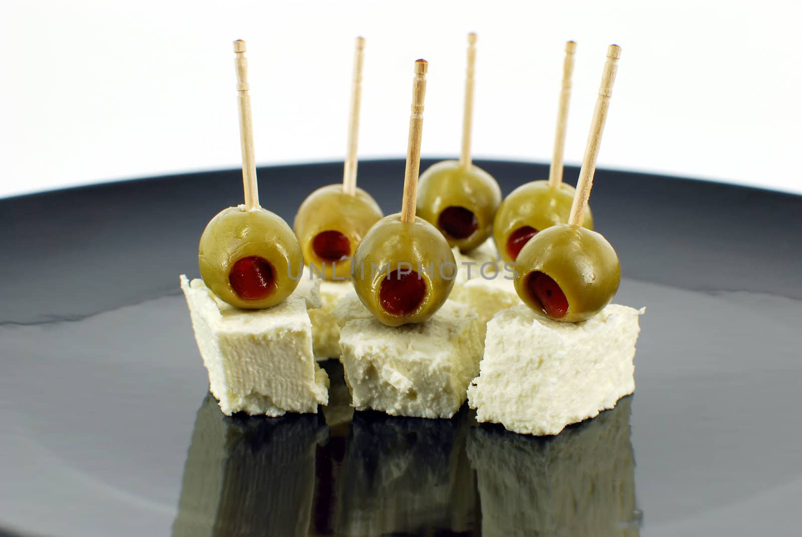 Olives and cheese on black dish