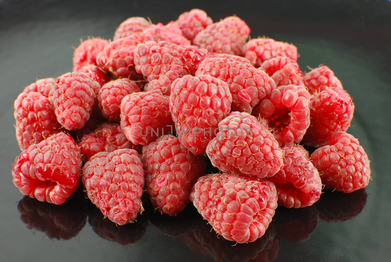 Fresh raspberry on black dish