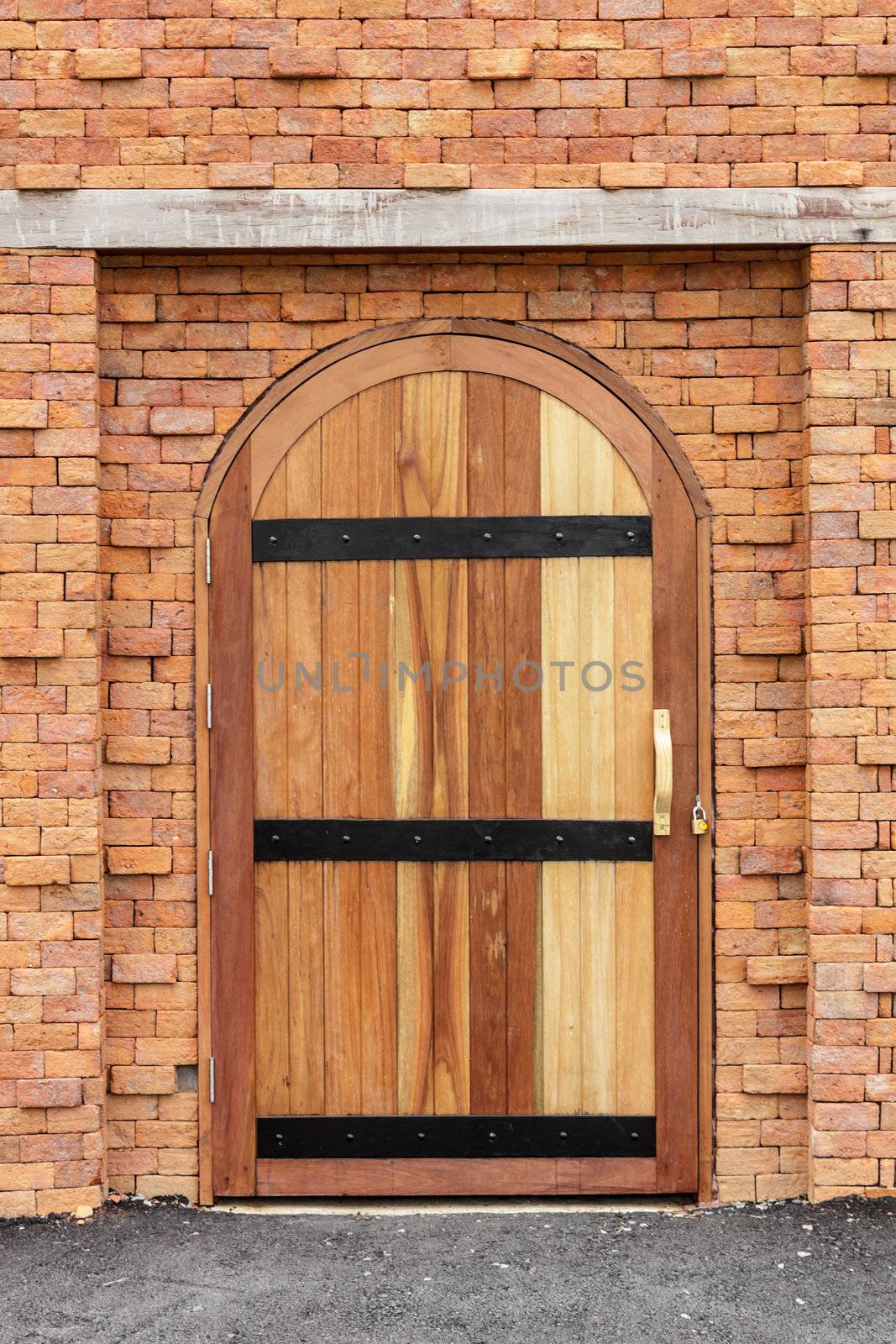 Strong wooden door on old brick wall.