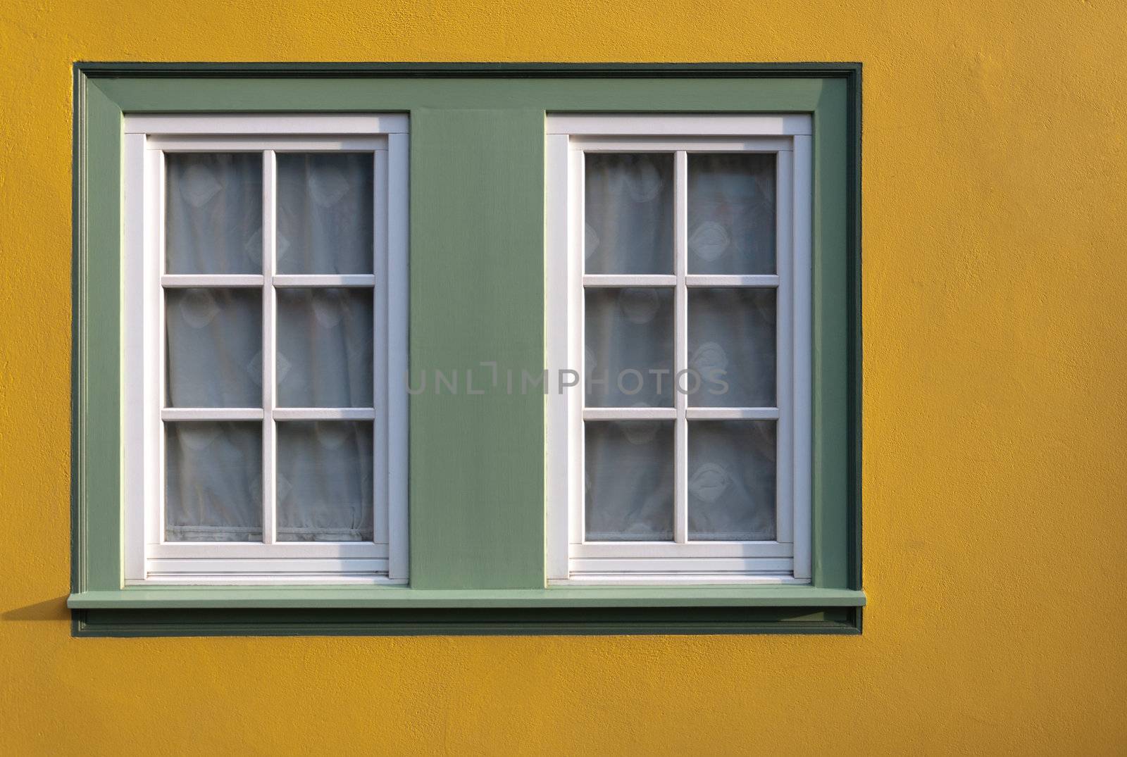Window on yellow wall of the house.