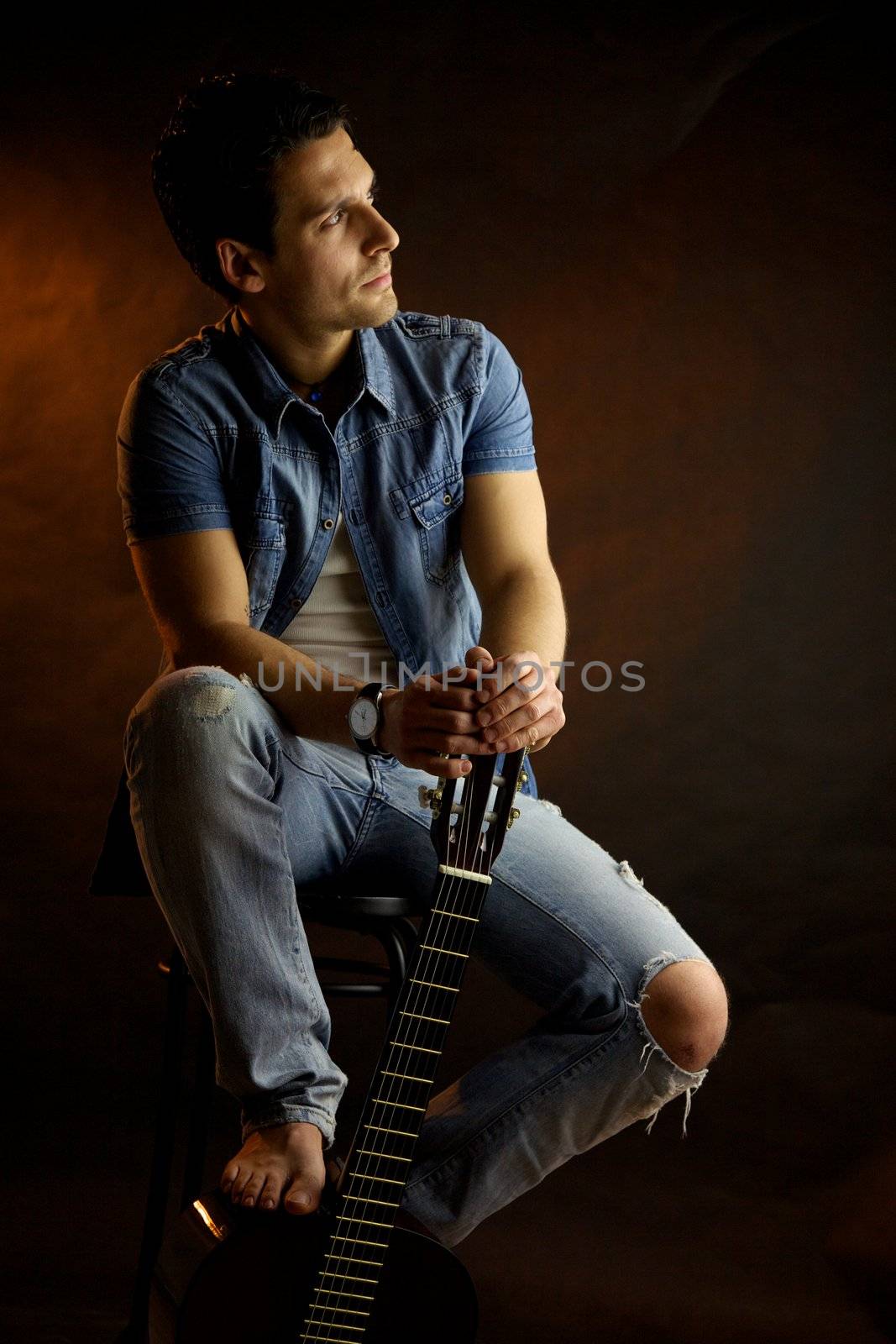 Serious male model with guitar thinking by fmarsicano