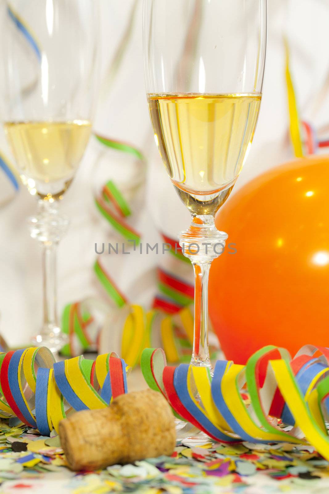 Two glasses of champagne and confetti and ballons