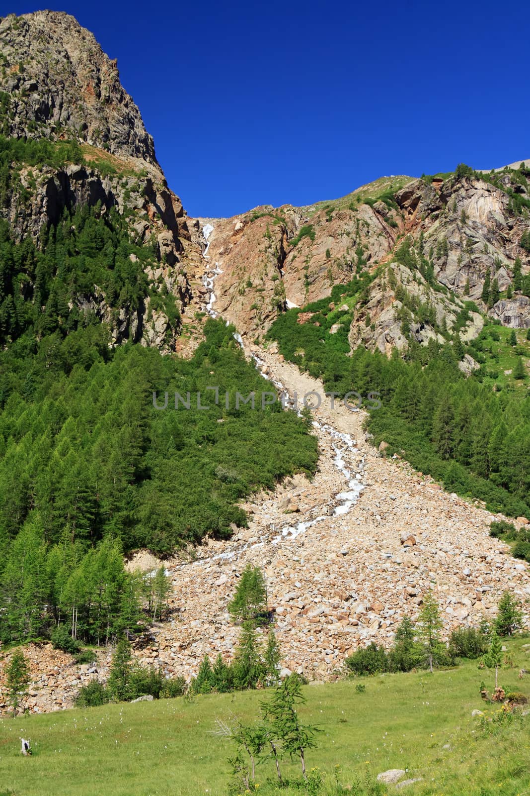 alpine landscape with a small stream and waterfall in Stelvio national park