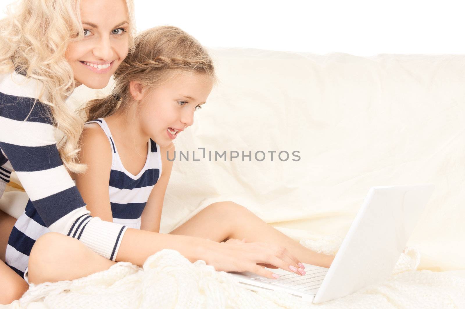 bright picture of happy mother and child with laptop computer (focus on girl)