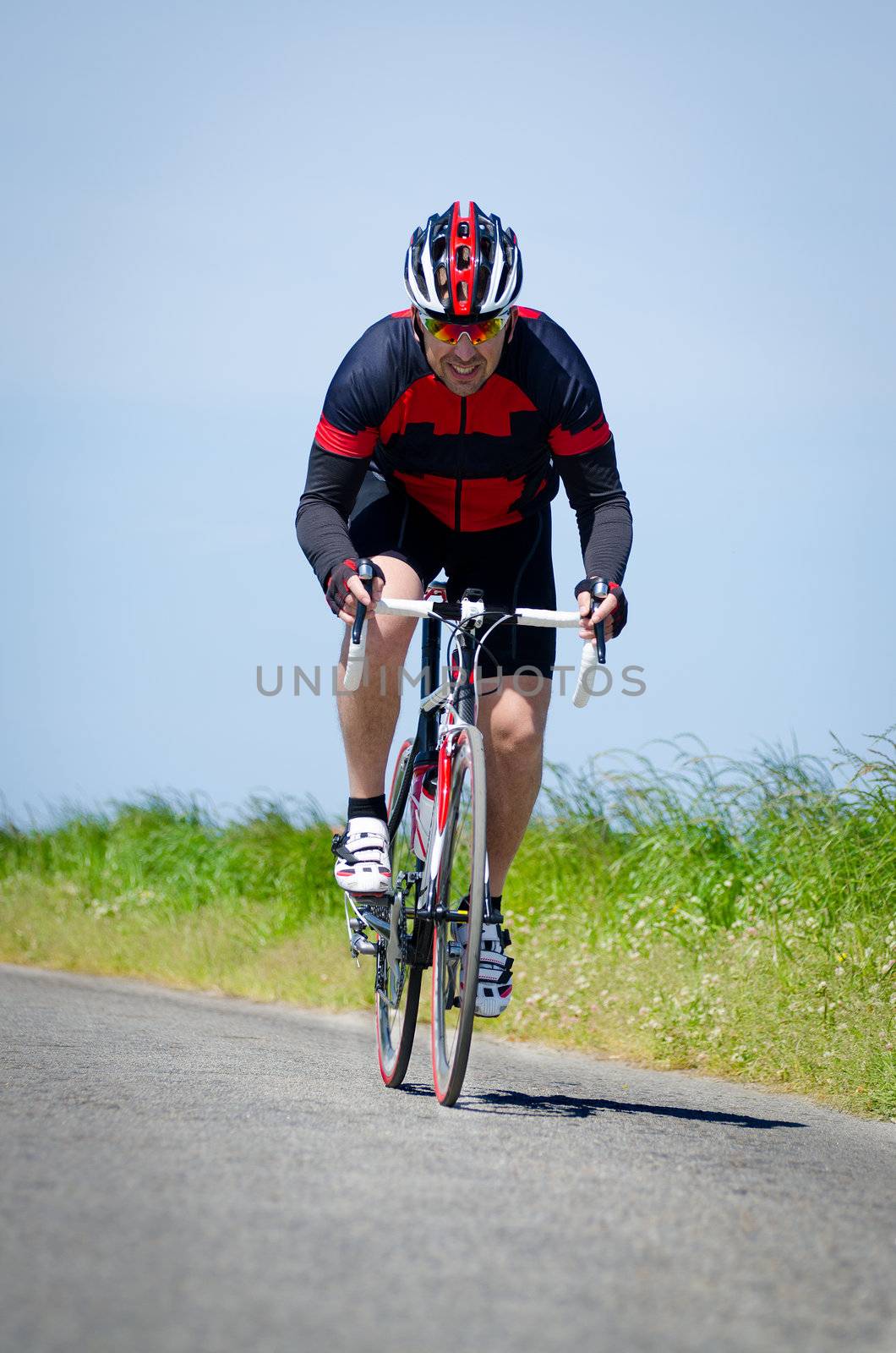 Man on road bike riding down open country road.