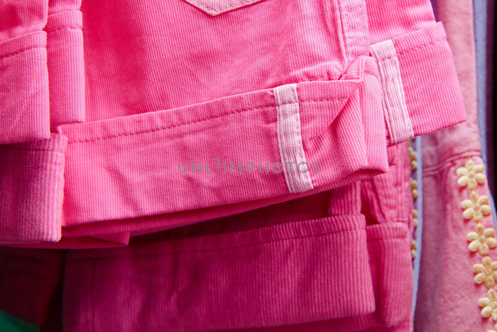 a lot of bright children's clothing on a hanger in the store
