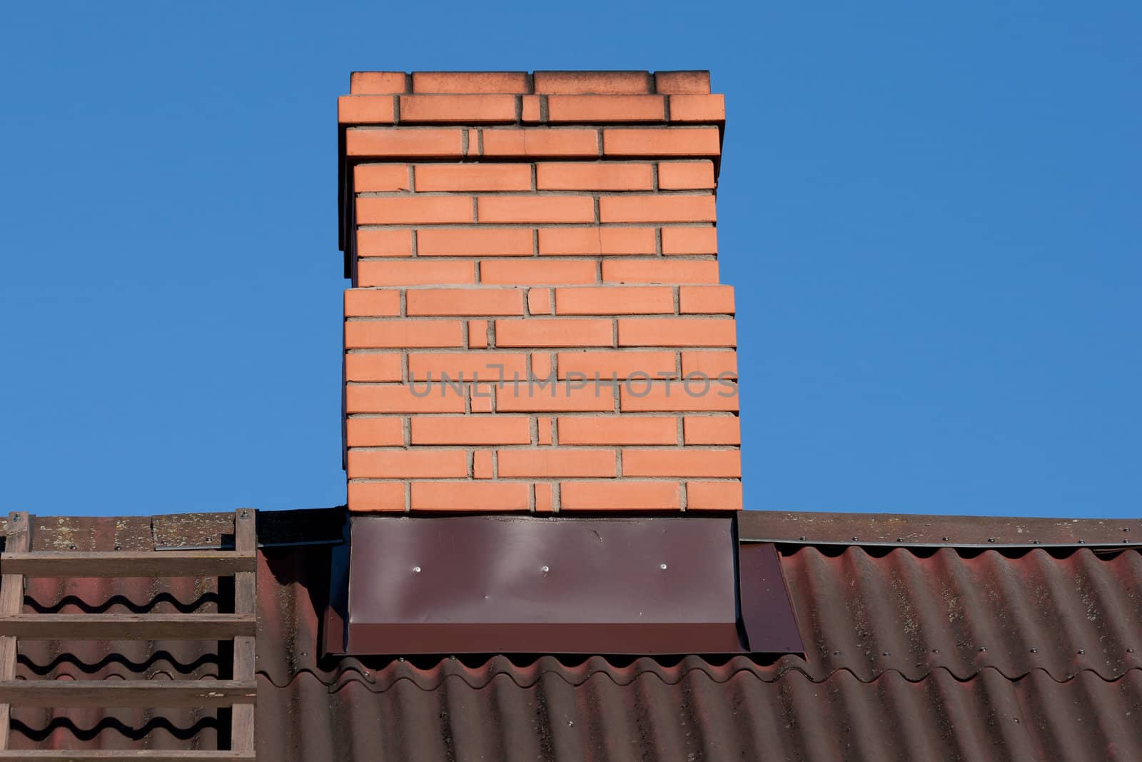 Rricks chimney on the dark  metal-sheet roof