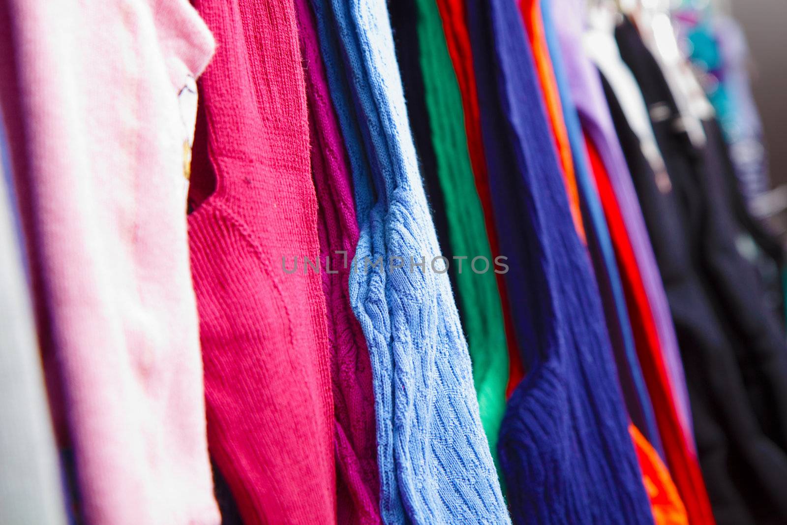 a lot of bright children's clothing on a hanger in the store