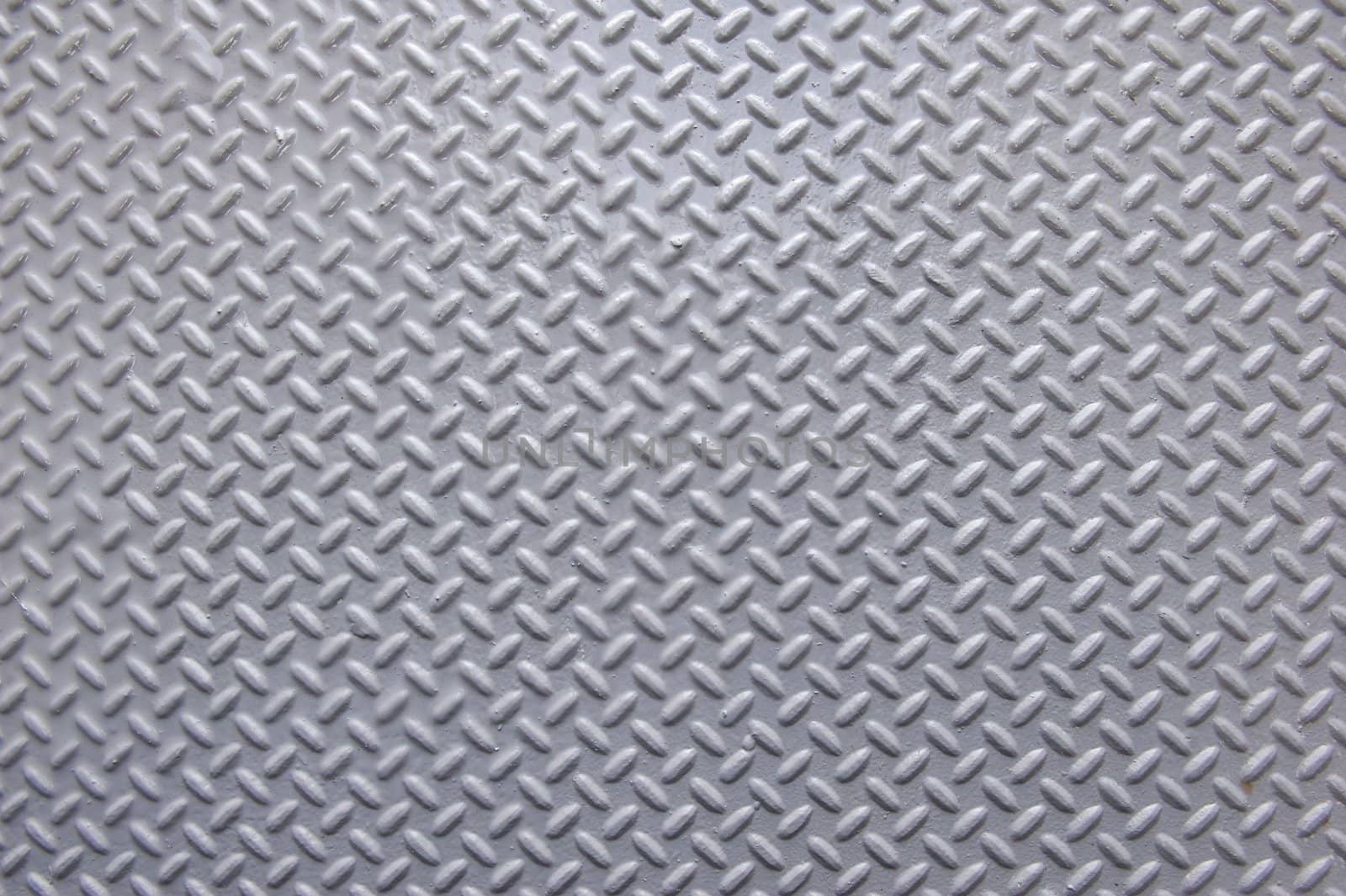 Background of painted metal with raised herringbone pattern