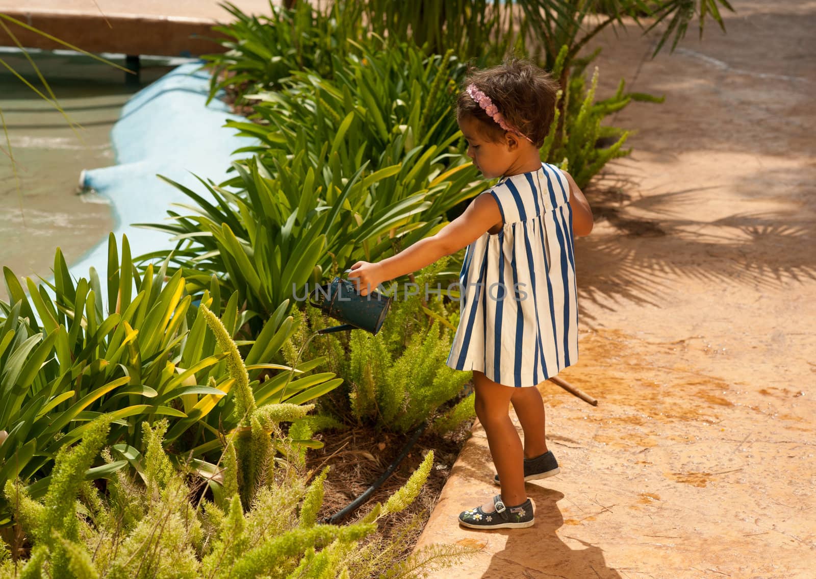 Infant having fun with a watering can