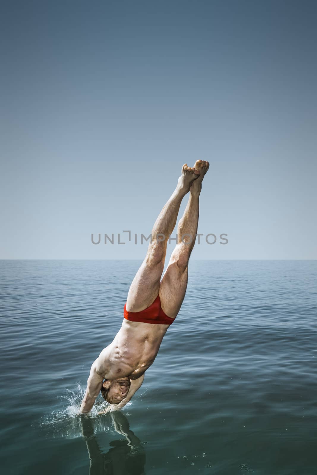An image of a handsome man jumping in the lake
