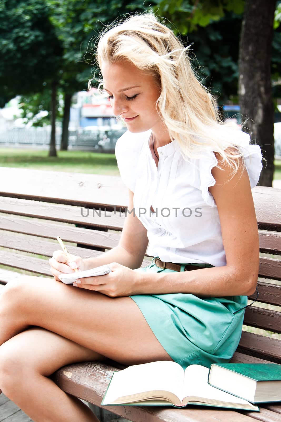 Young and beautiful female student preparing for exams in the park