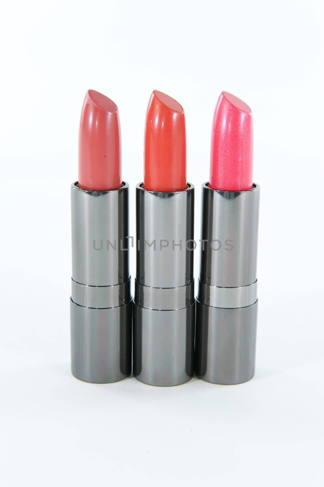 Three lipstick cases standing in a row on a white or blank background