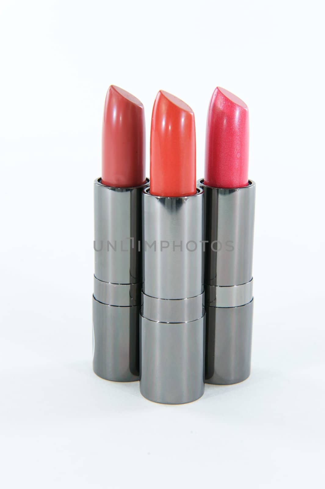 Three lipstick cases standing in a cluster on a white or blank background
