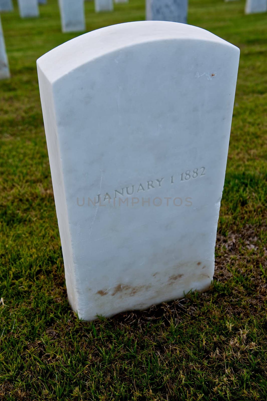White marble slab headstone or gravestone in a green military cemetery