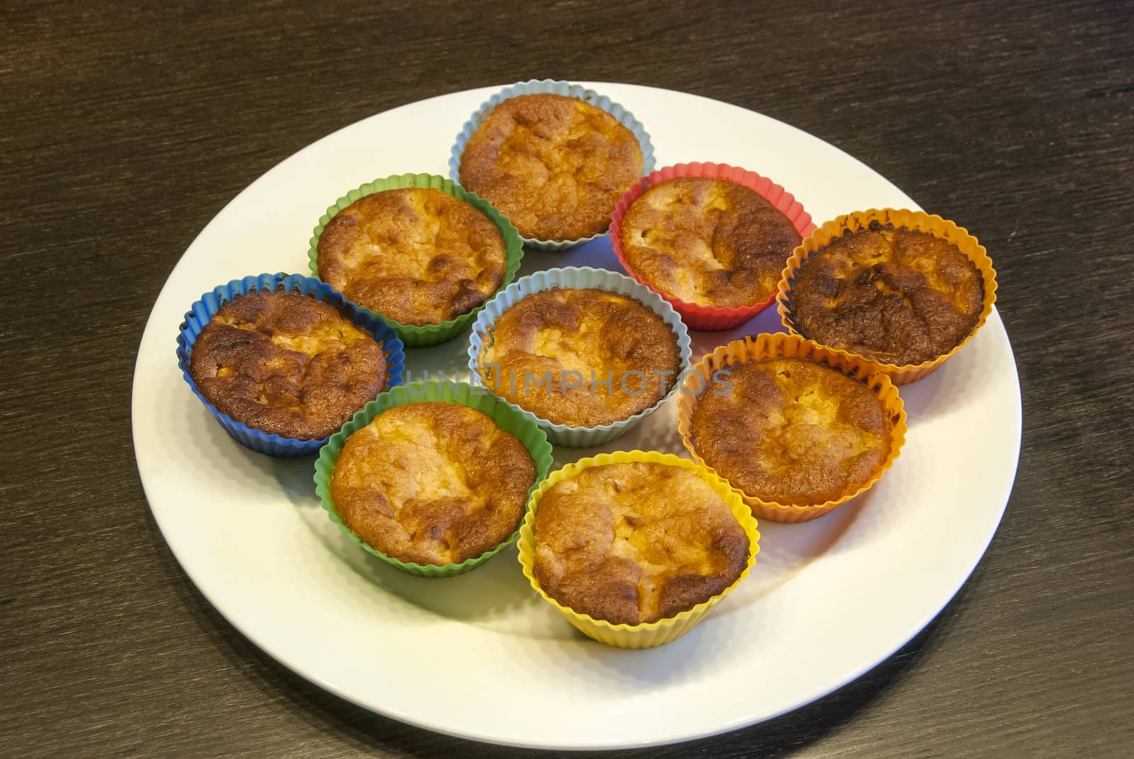 Homemade muffins on plate on brown table