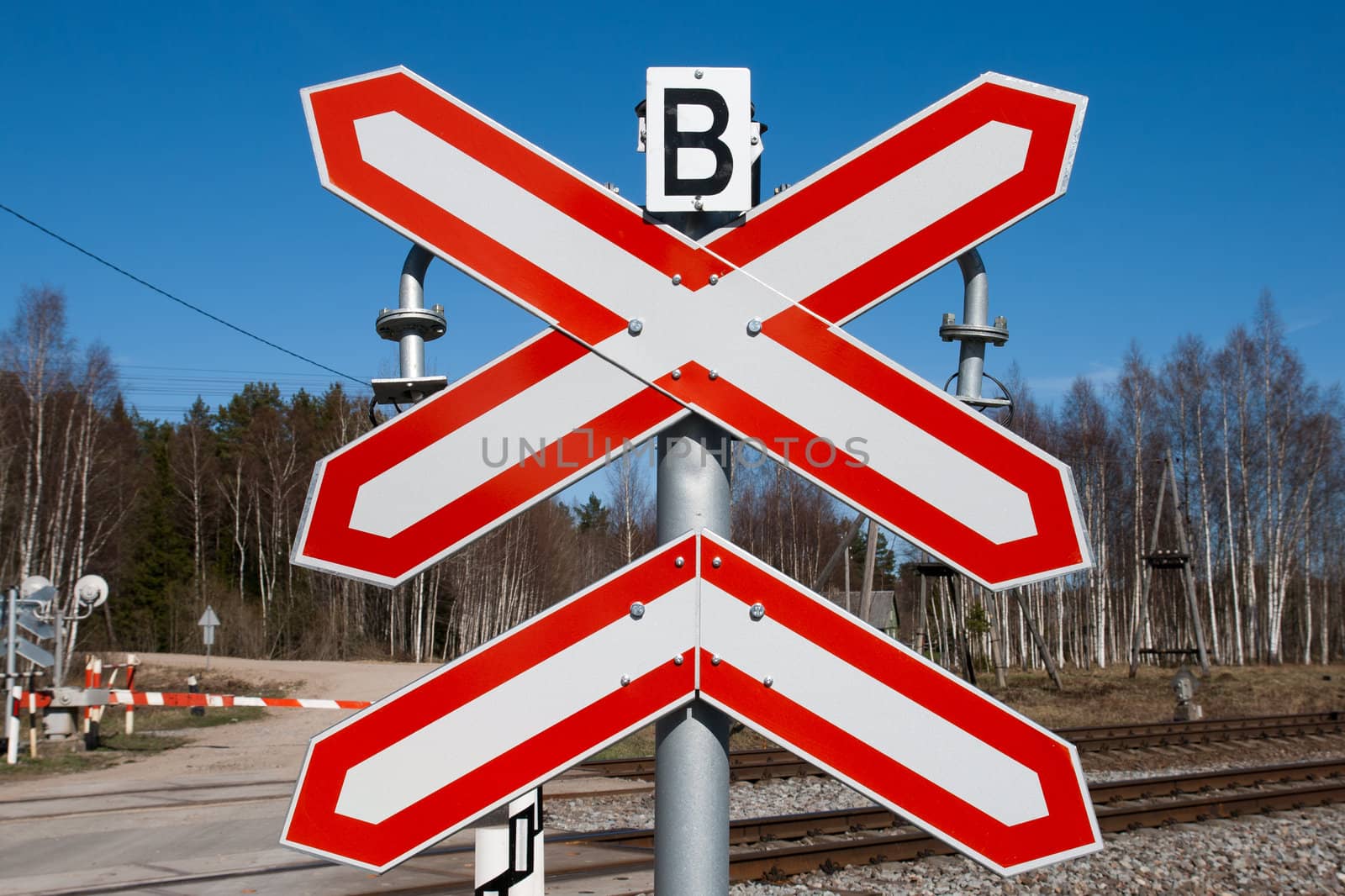 red-white railway sign against a blue sky.