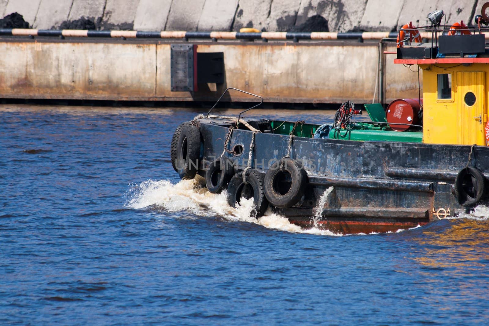 small tugboat float in river with blue water