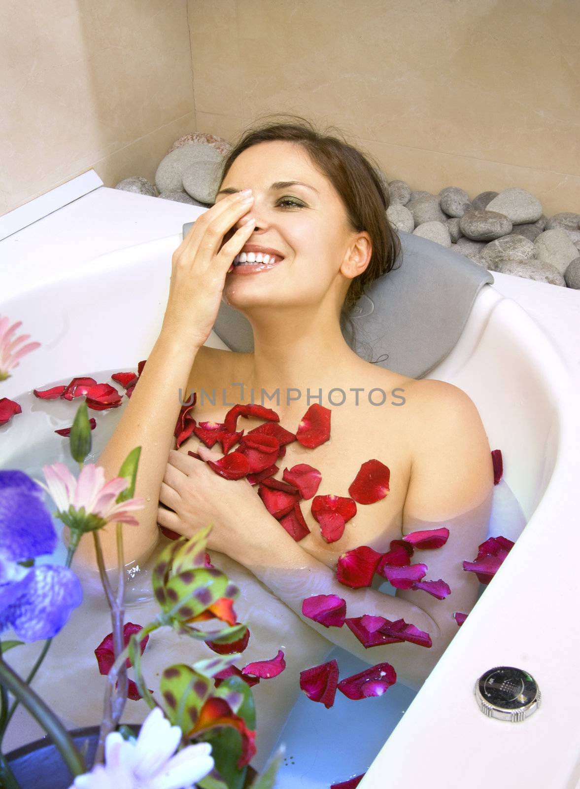 happy woman in a bath with rose-petals by ssuaphoto