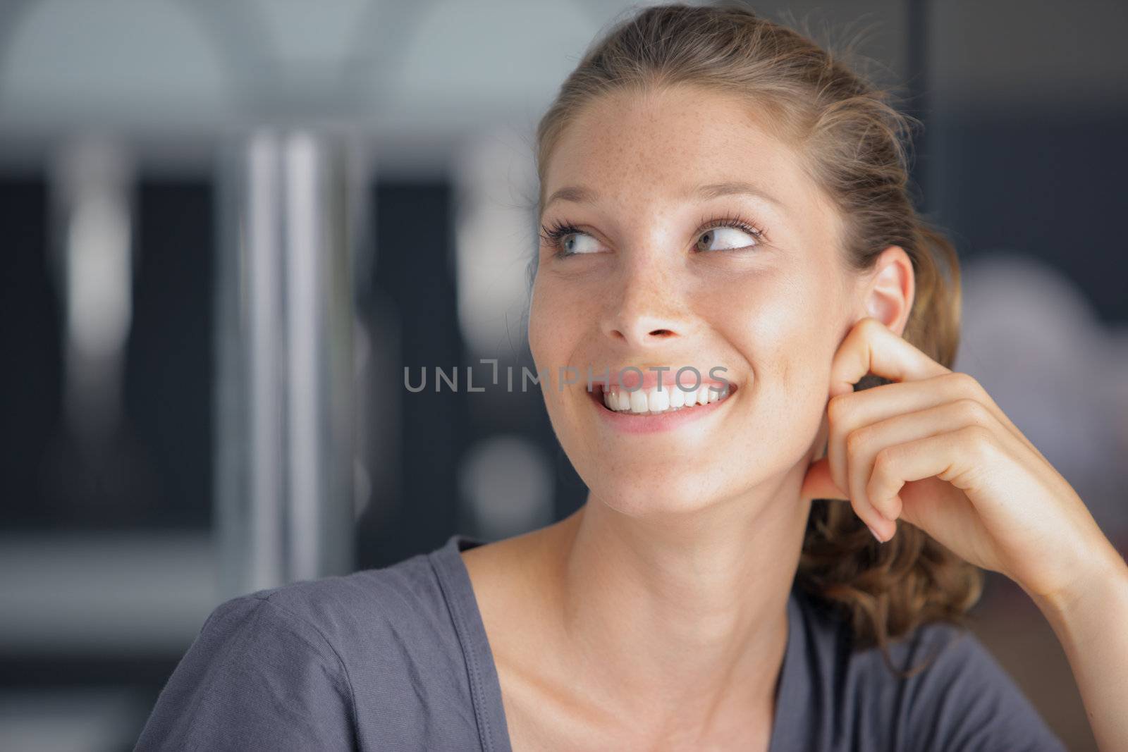 Portrait of a beautiful young woman, looking up into the corner on copy space.