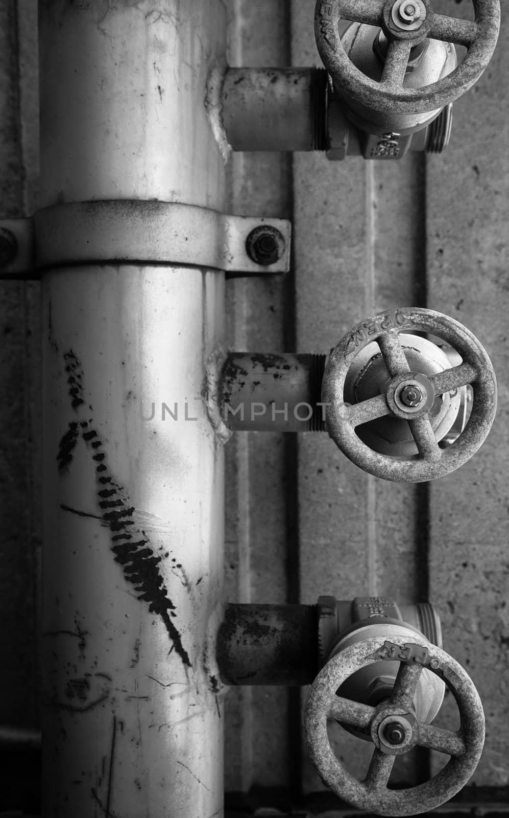 Old rusty pipe and valves concret background