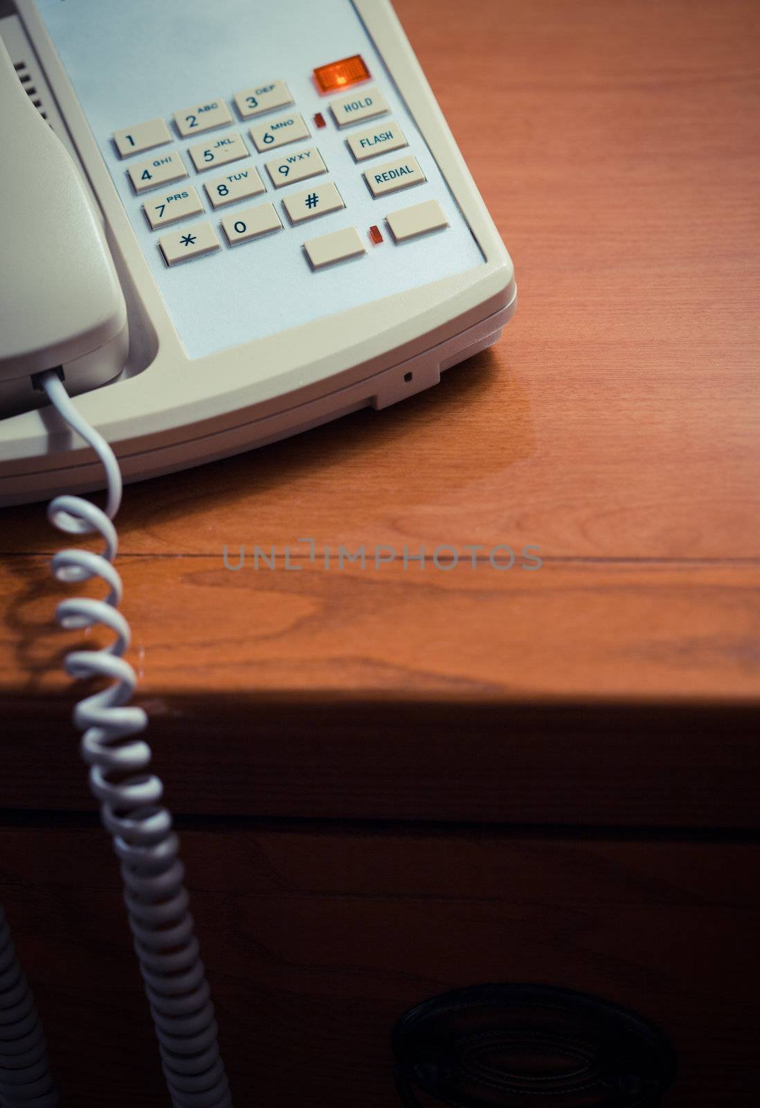 Hotel room phone on a wood desk