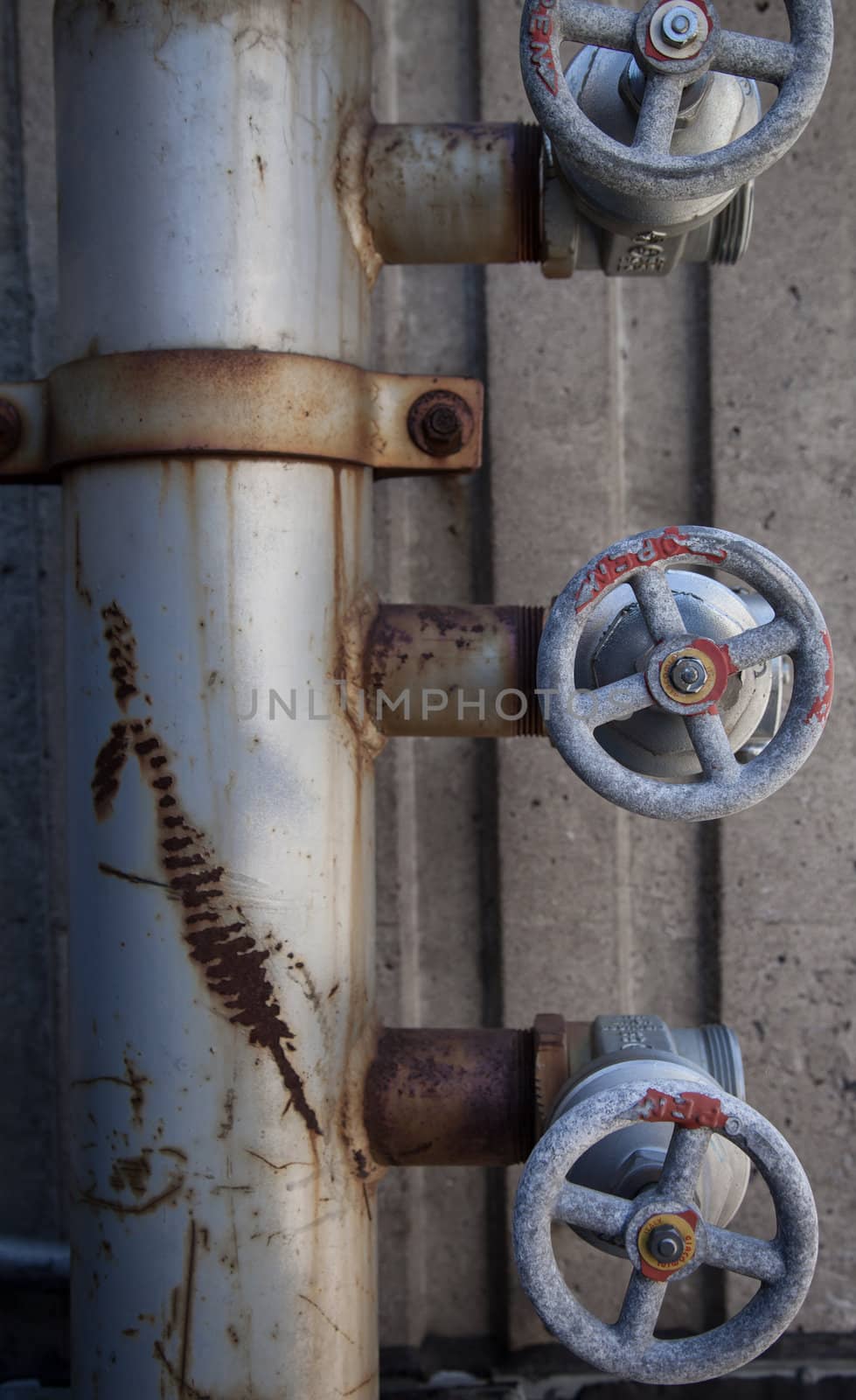 Old rusty pipe and valves concret background
