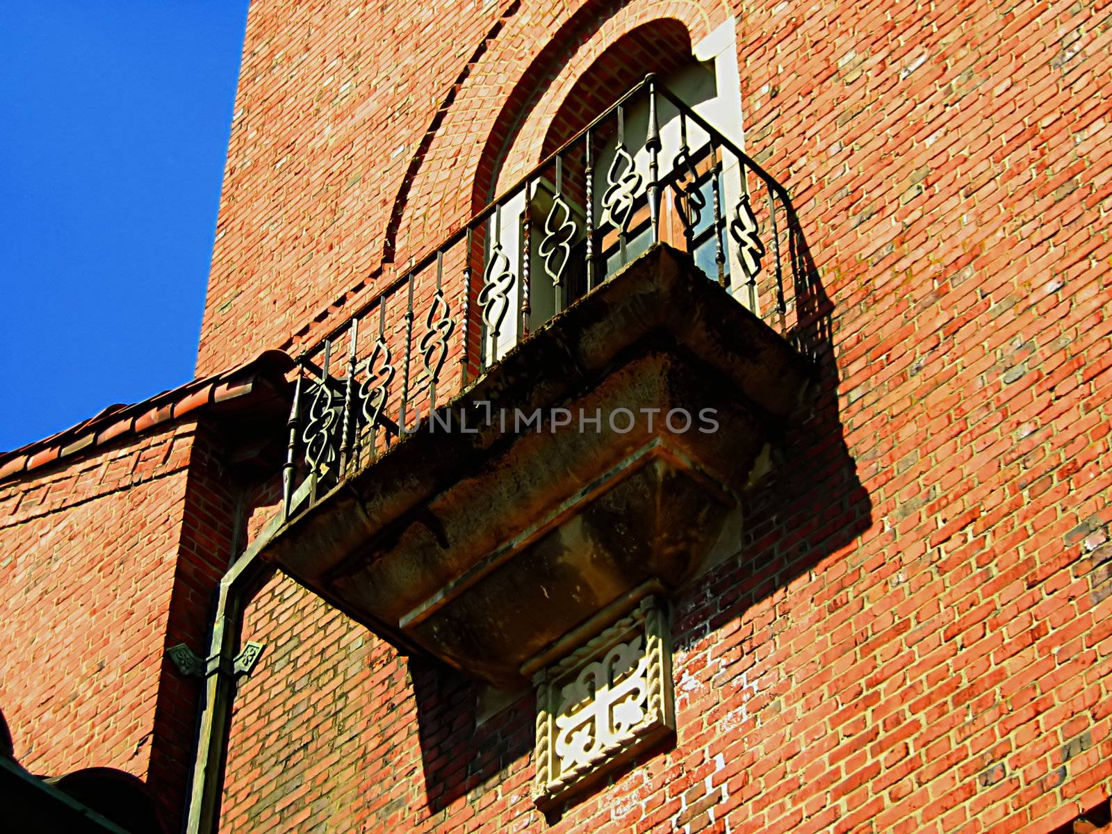 A photograph of a balcony and window detailing their beautiful architectural design.