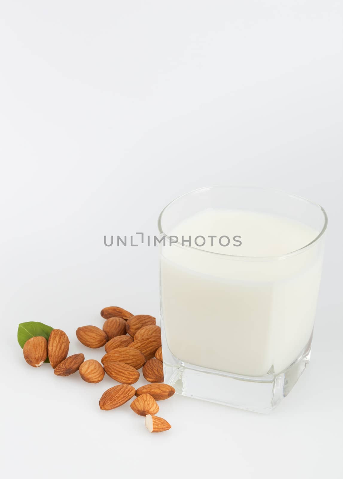 Almond milk with almonds on a white background