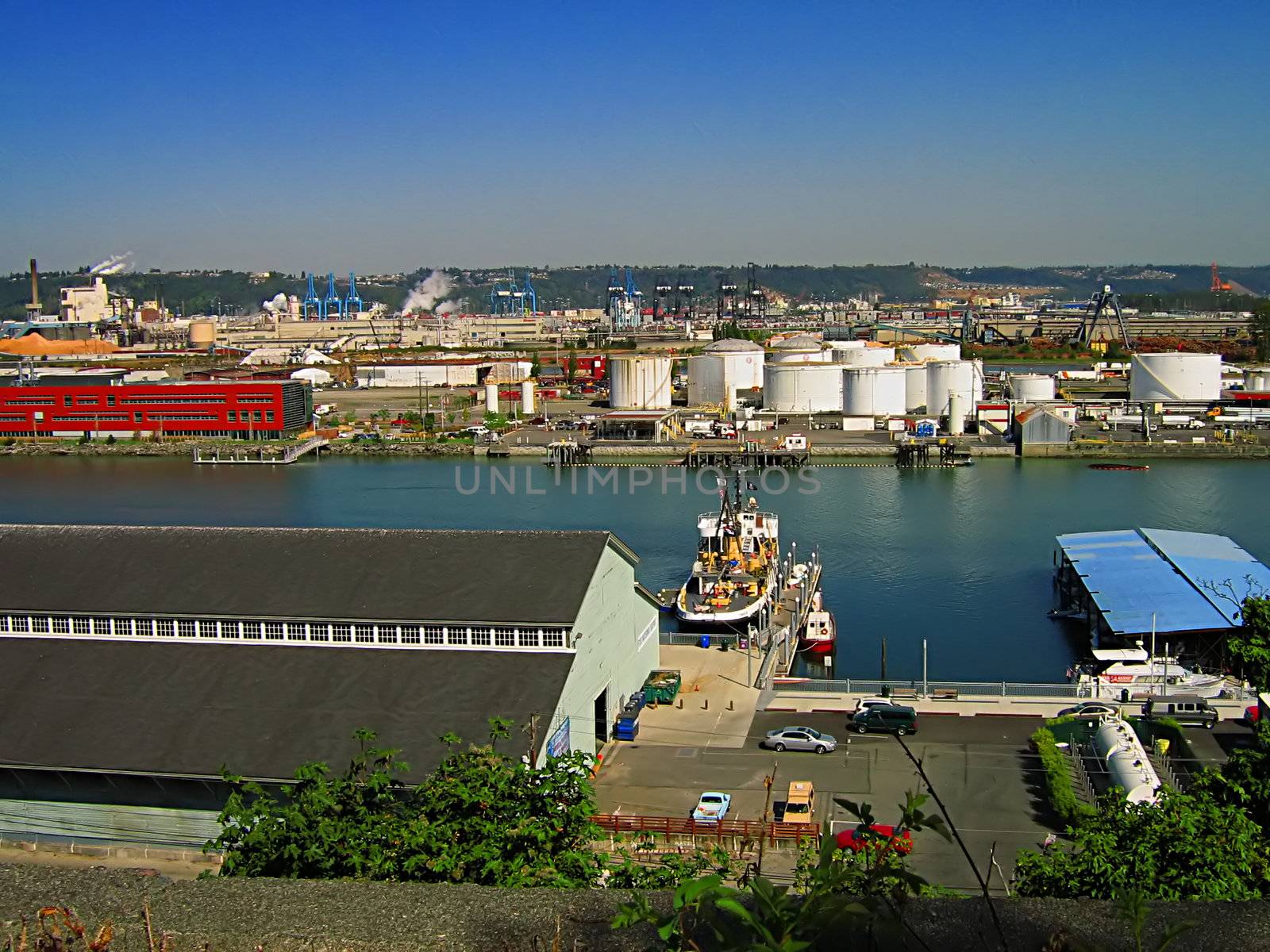 A photograph of an urban manufacturing and commerce area located near a waterway.