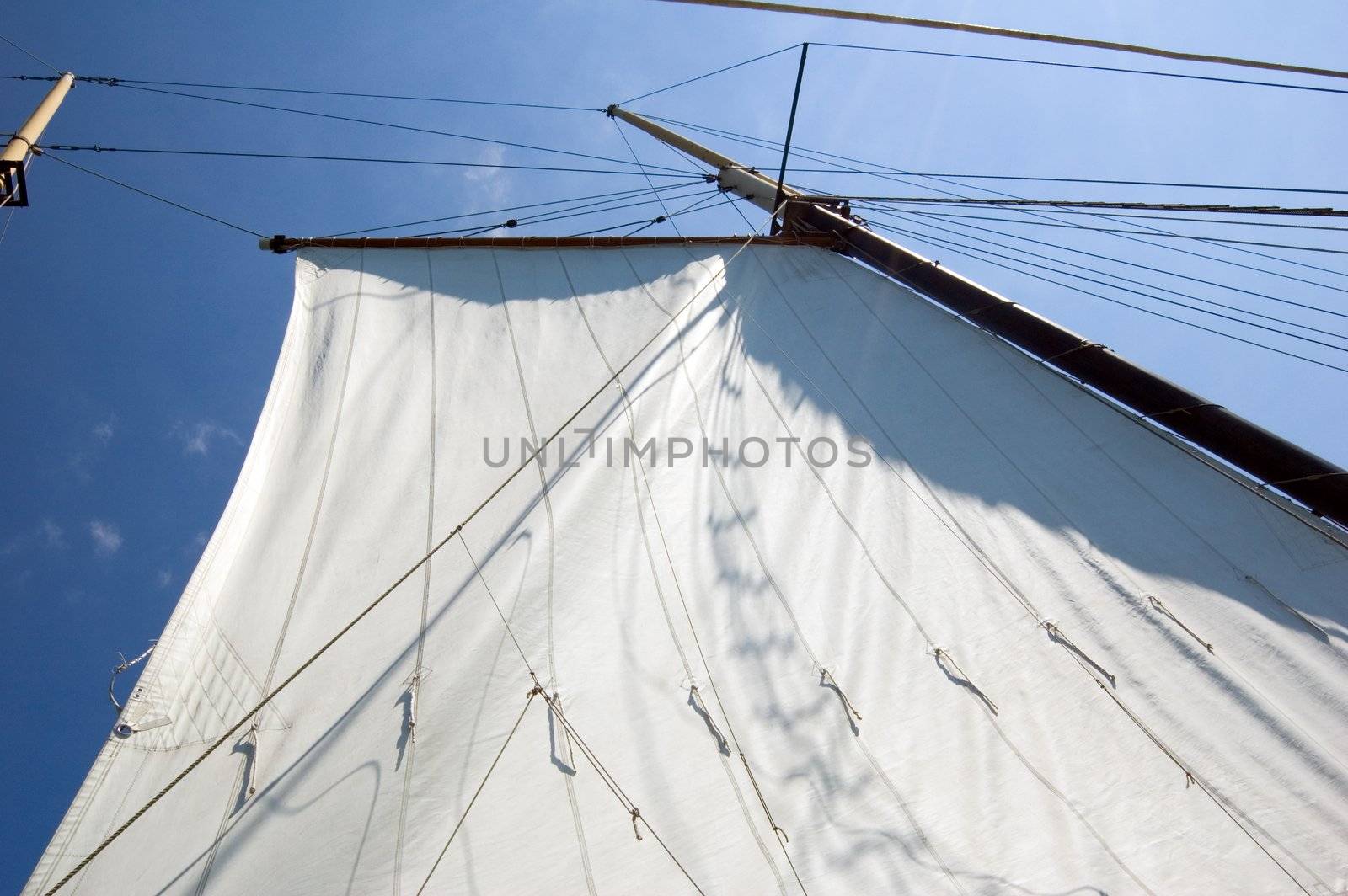 Big sails and masts on blue sky background