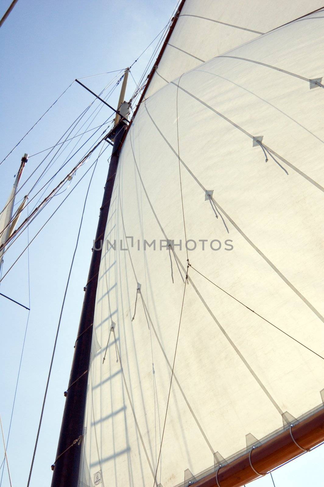 Big sails and masts on blue sky background