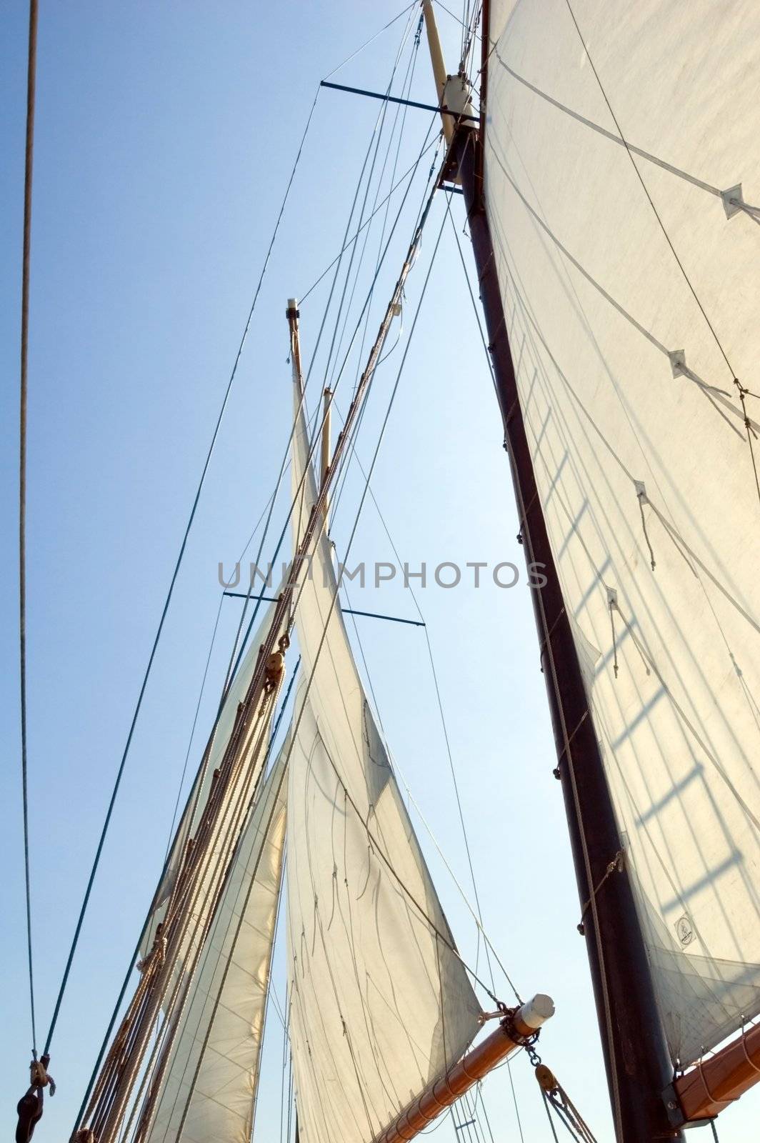 Big sails and masts on blue sky background