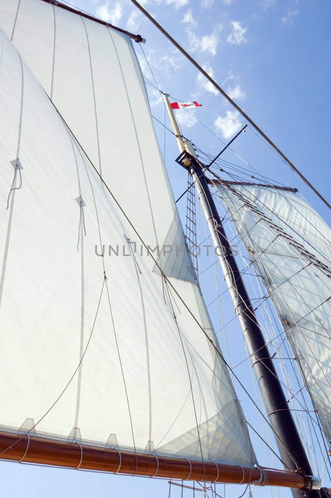 Big sails and masts on blue sky background