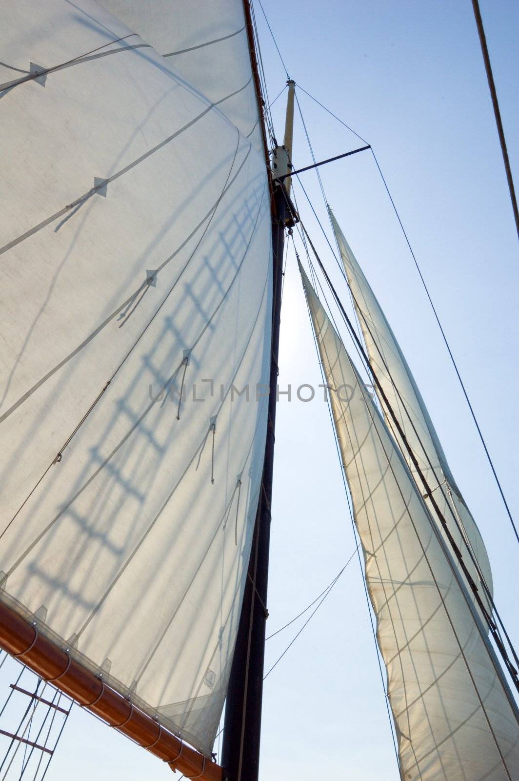 Big sails and masts on blue sky background