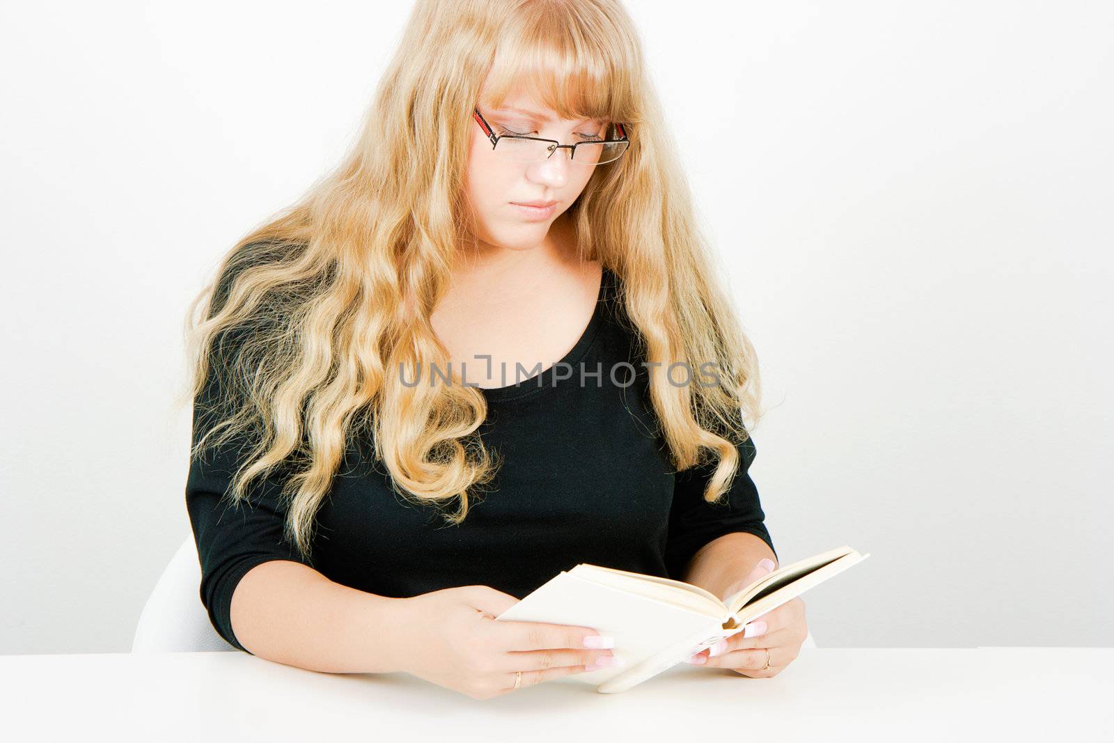 blonde girl with glasses reading a book