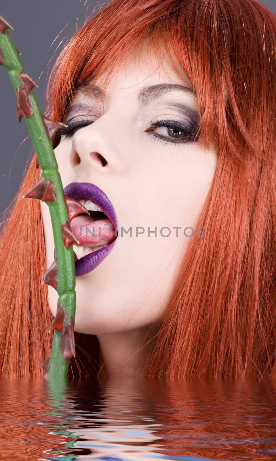 closeup portrait of redhead woman licking sharp thorns