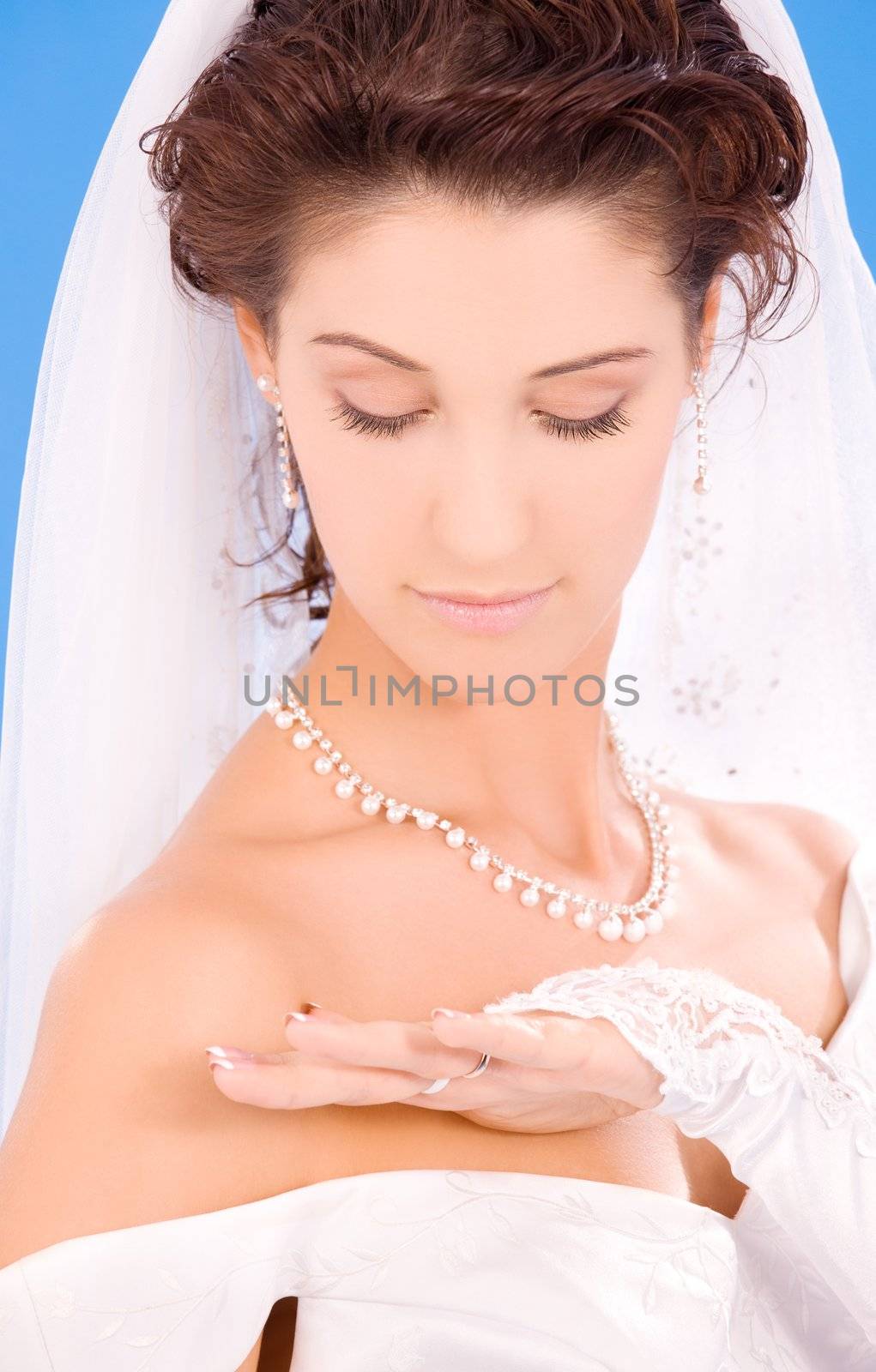 happy bride with her wedding ring over blue