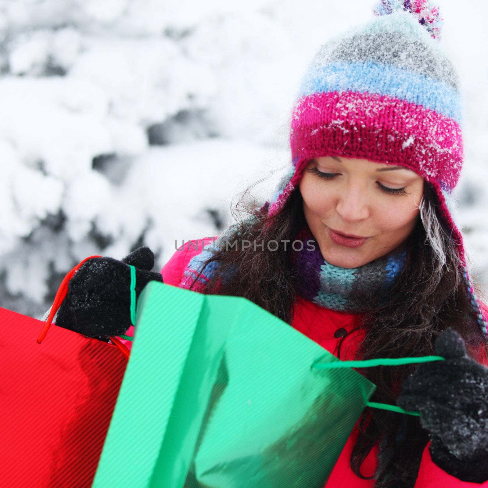 winter girl with gift bags on snow background