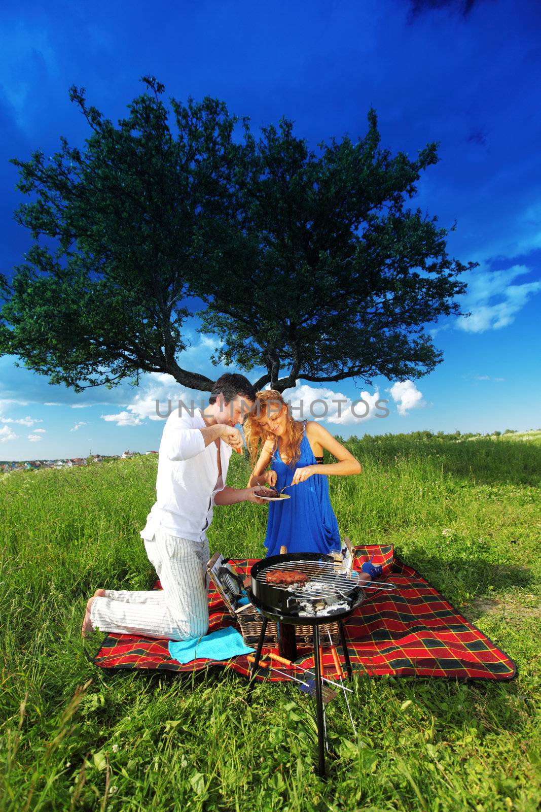 man and woman on picnic in green grass