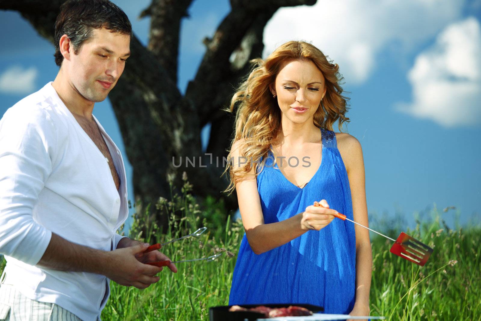 man and woman on picnic in green grass