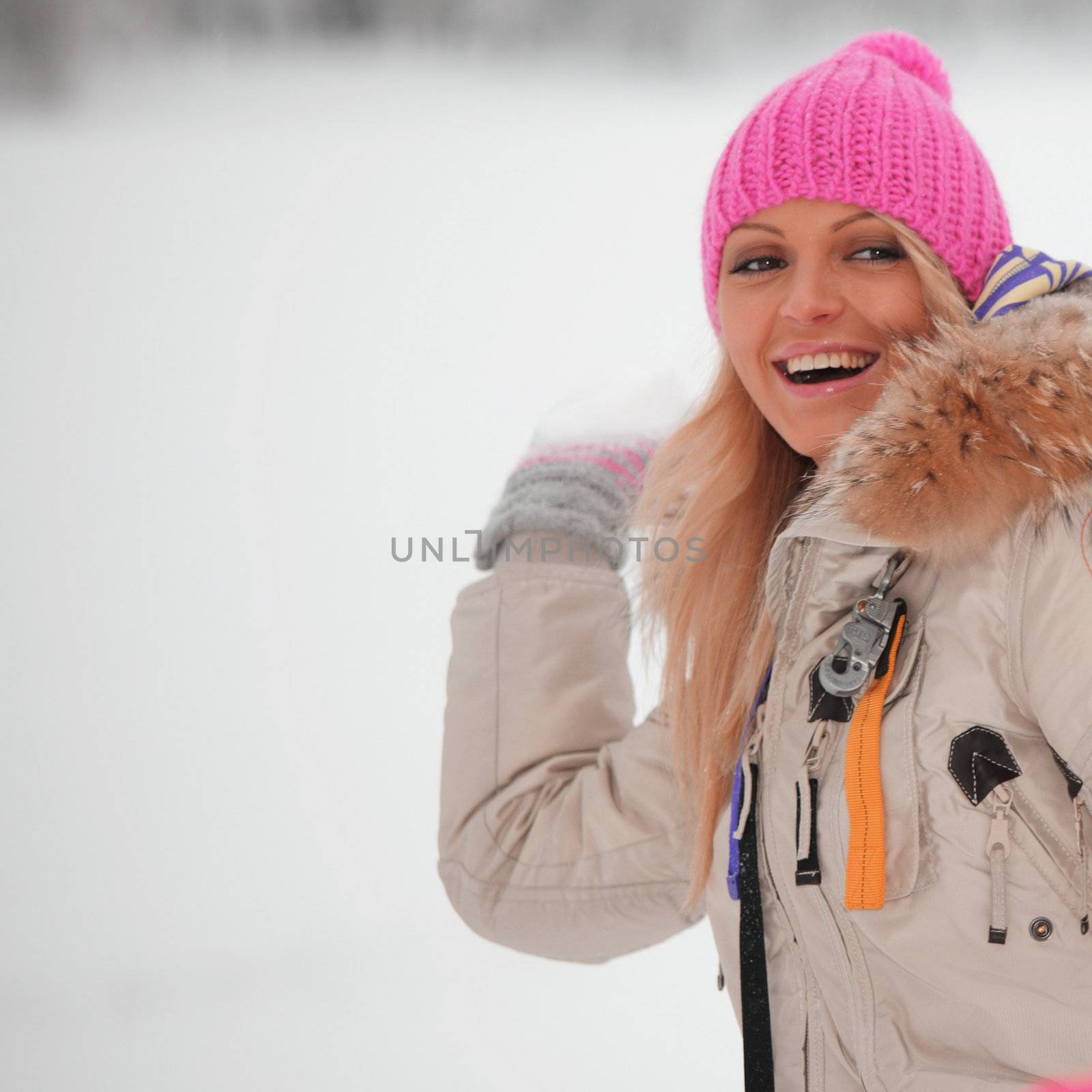 winter woman play snowballs on snow background