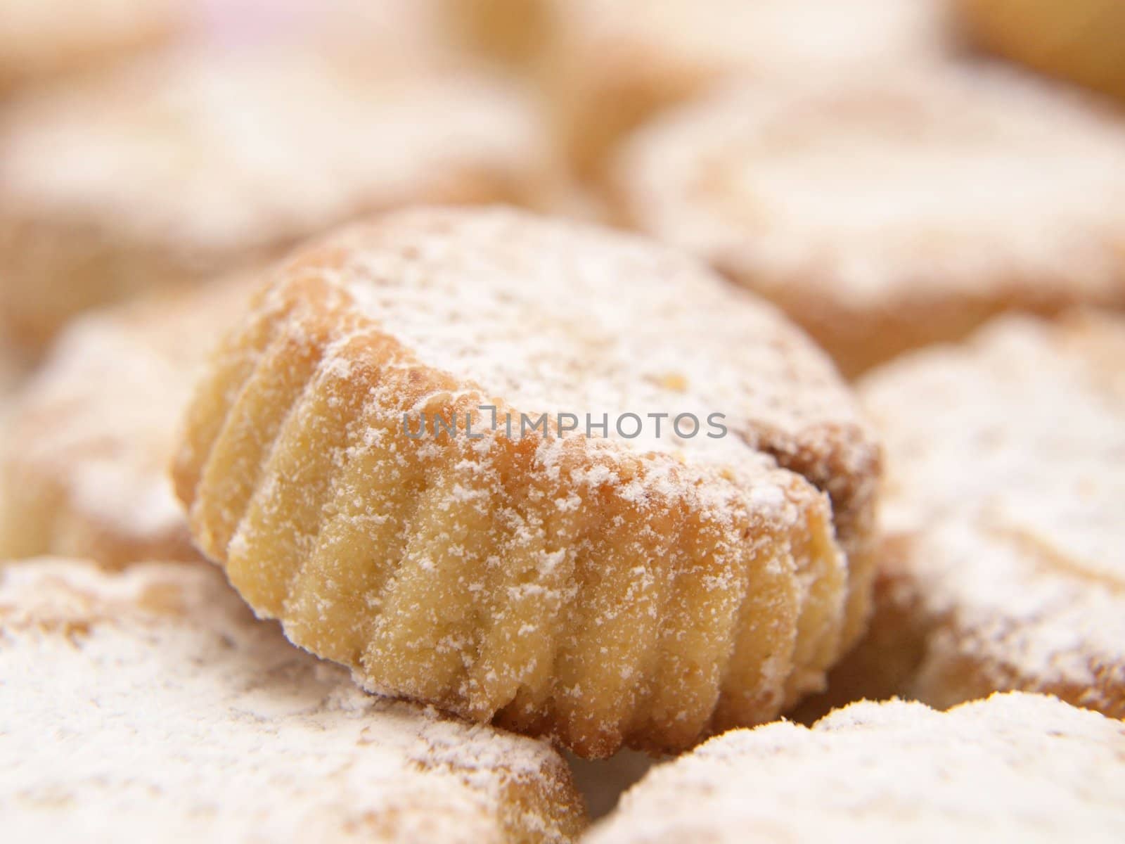 Cupcakes with icing sugar, in a pile, macro by Arvebettum