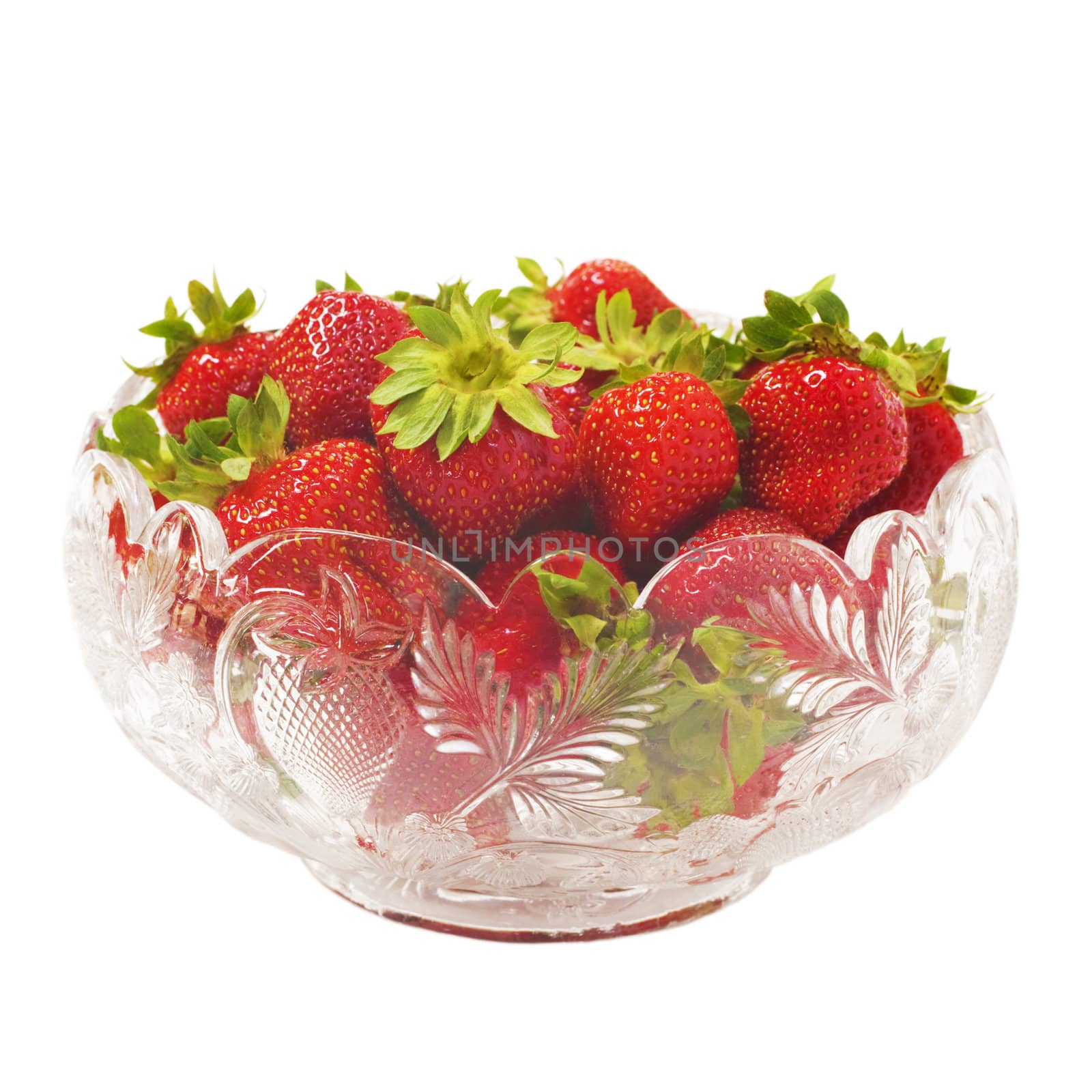 An antique glass bowl filled with summer's bounty, luscious strawberries. Isolated on white.